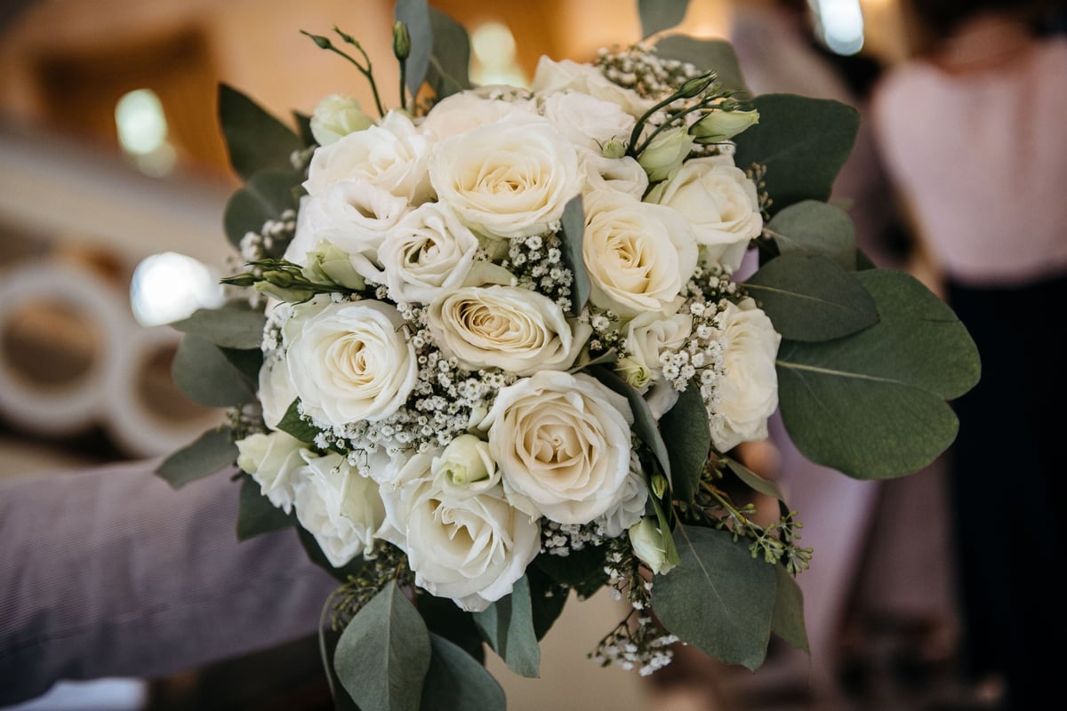 Beautiful bridal bouquet of white roses and greenery